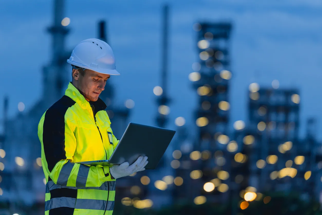 Ingeniero hombre técnico masculino trabajando en el turno de noche con dispositivo de tecnología de tableta en el servicio in