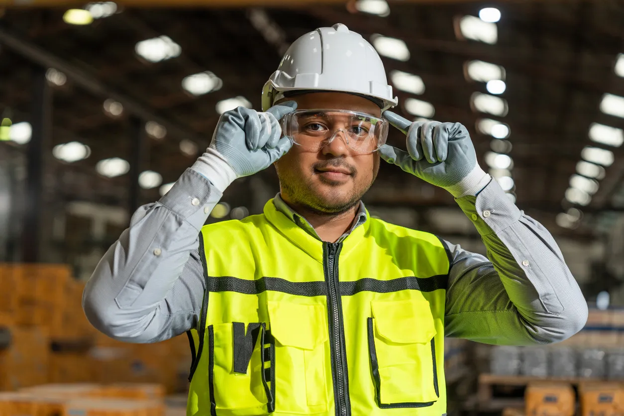 Cierre el ingeniero técnico que usa y ajuste las gafas de seguridad protectoras