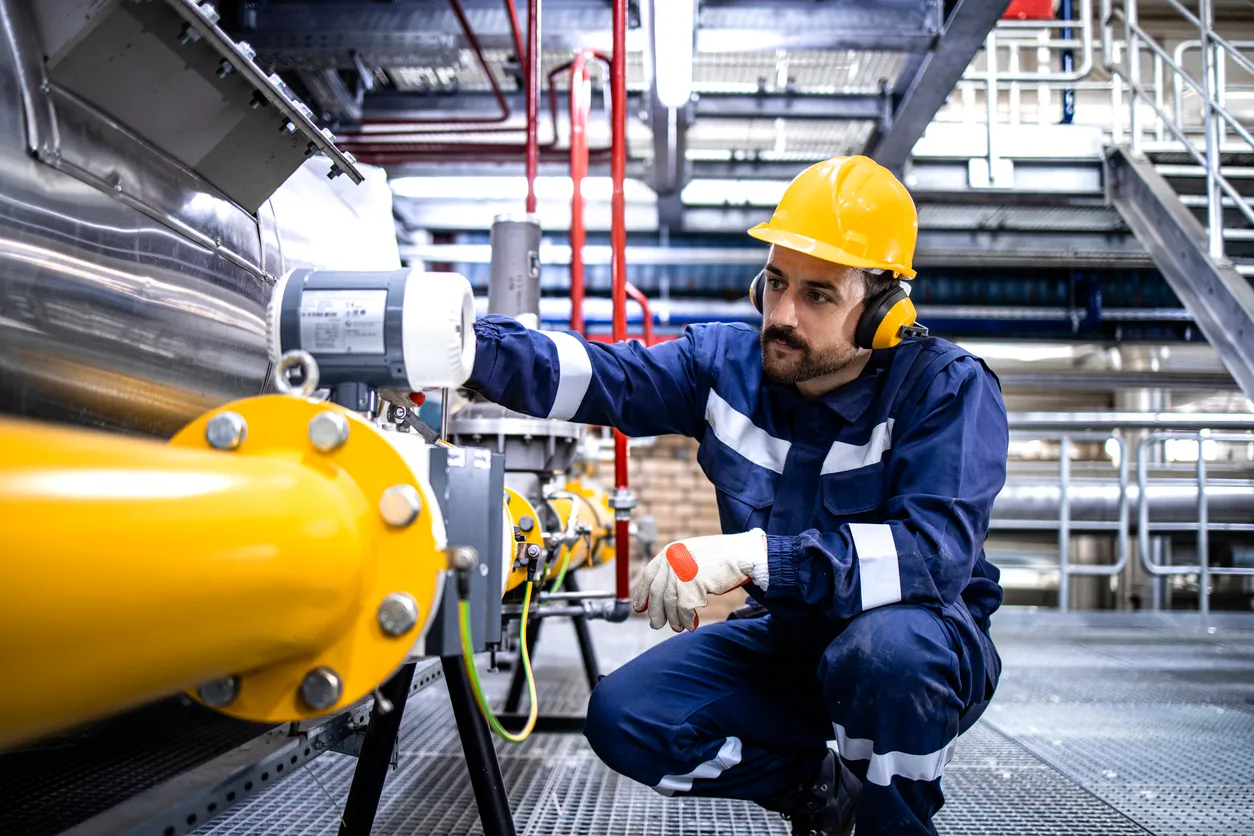 Trabajador de cuello azul de la refinería de pie junto al gasoducto de GLP y verificando la producción o distribución de gas