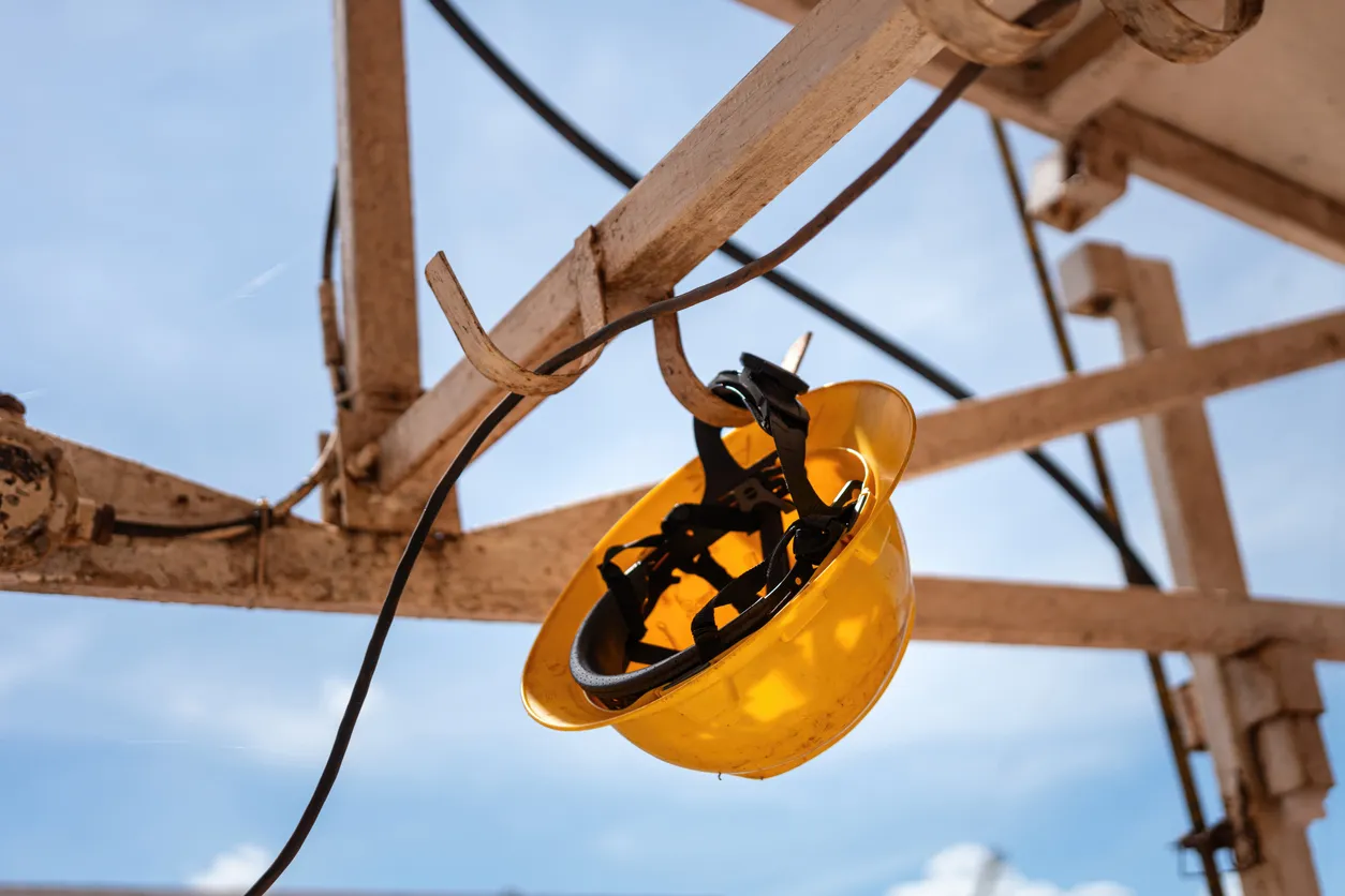 Un casco de seguridad amarillo o casco de obrero de la construcción cuelga de la barandilla.