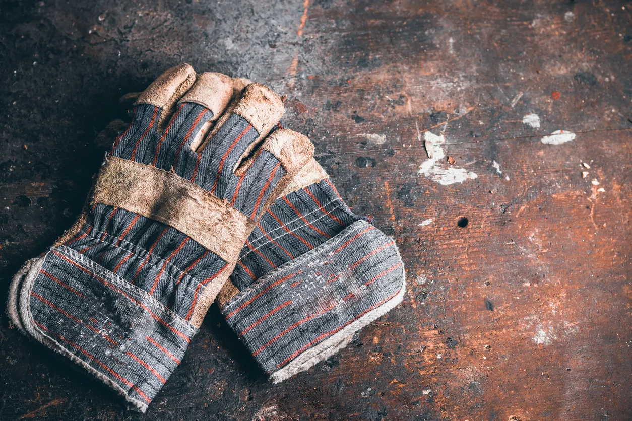 Un par de guantes de trabajo de protección en un banco de trabajo de madera. 