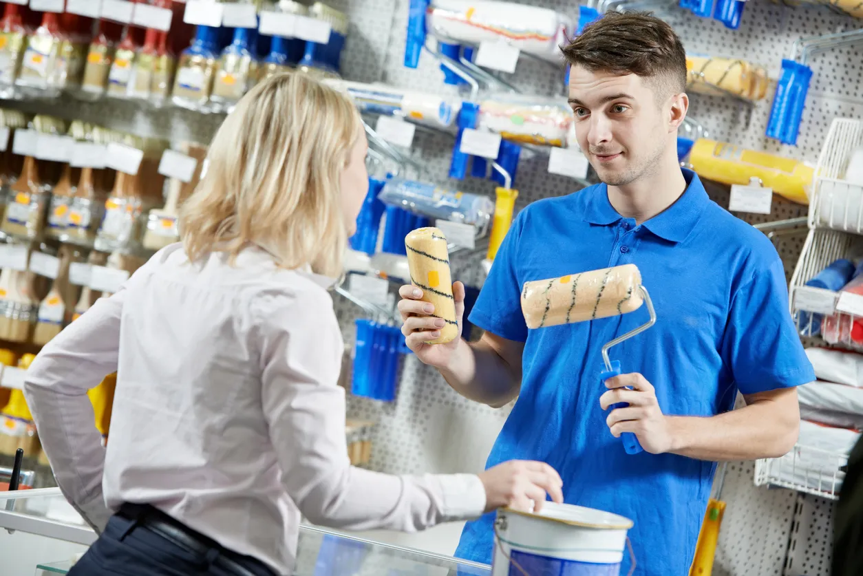 Vendedor demostrar rodillo de pintura al encargado de compras 