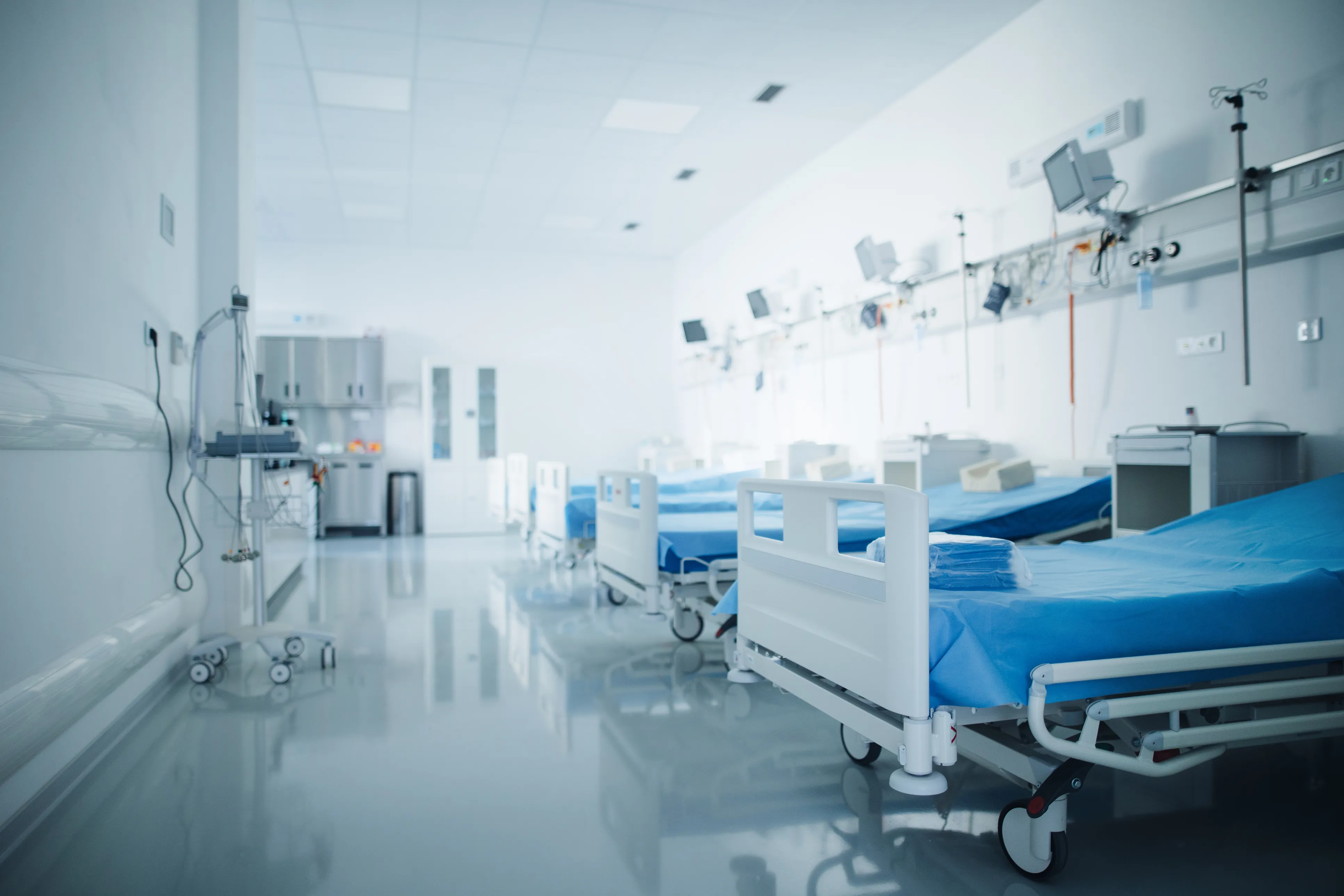 Varias camas vacias con sábanas desechables en hospital 