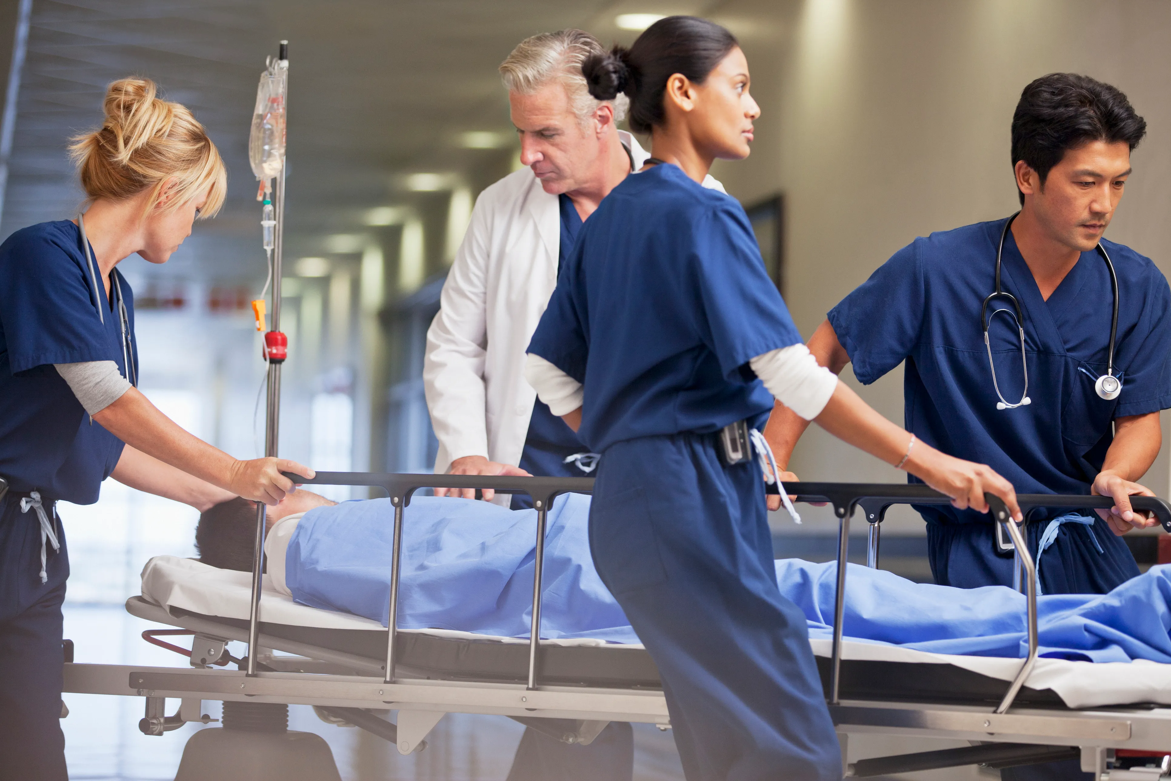 Doctores y enfermeras llevando a paciente en una camilla 