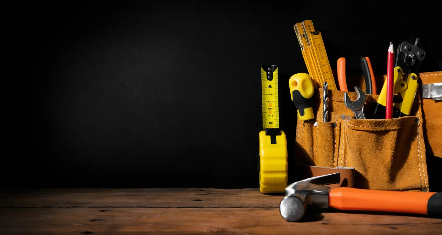 Mejoras para el hogar: herramientas de construcción sobre fondo negro con espacio de copia. estandarte 