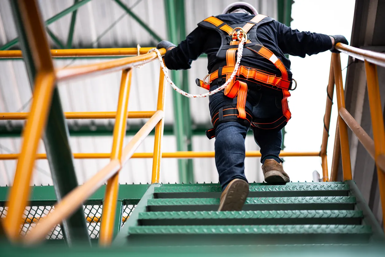 Trabajador de la construcción que lleva arnés de seguridad 