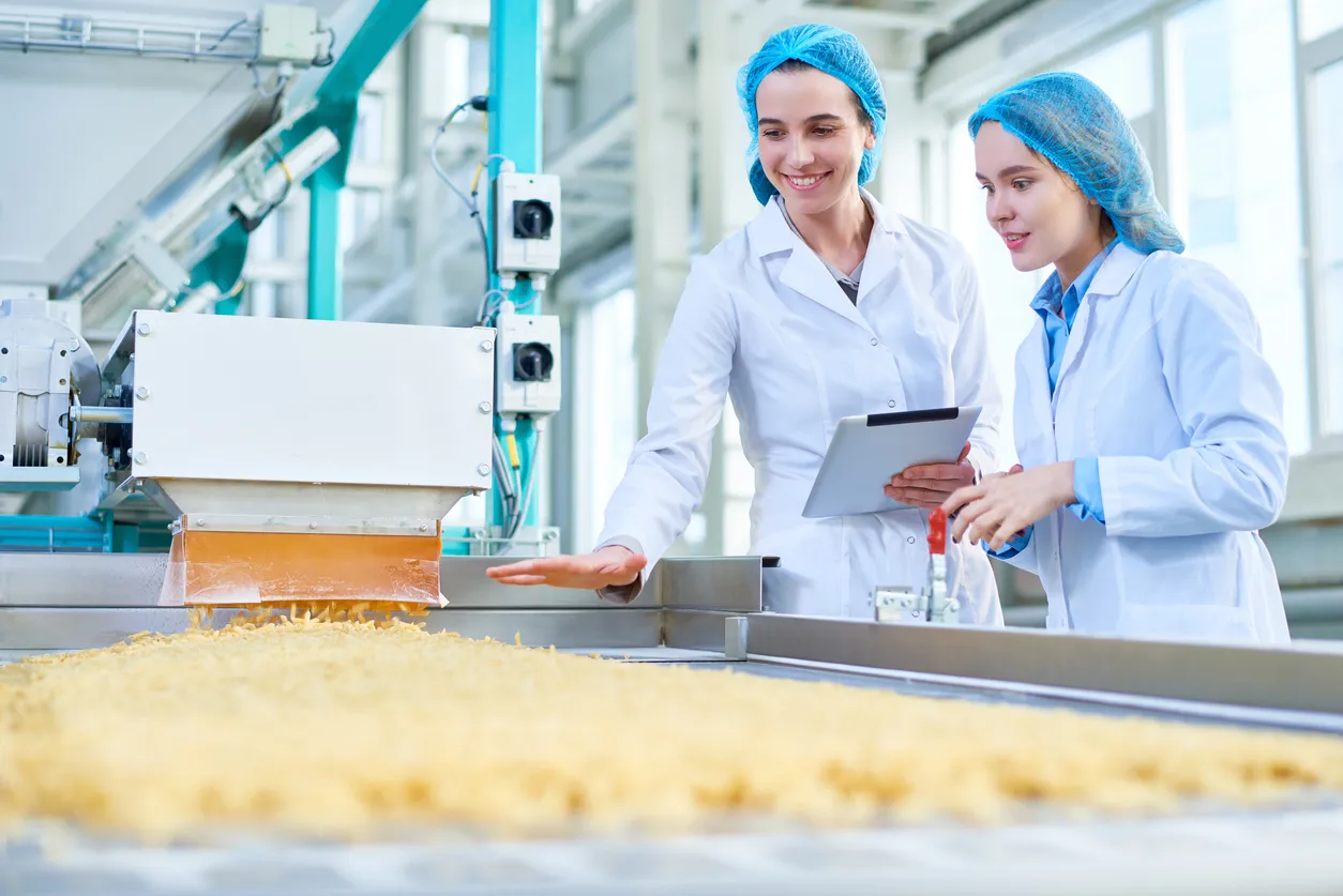 Joven consultora en sistemas de gestión realizando una revisión en los procesos en industria alimentaria