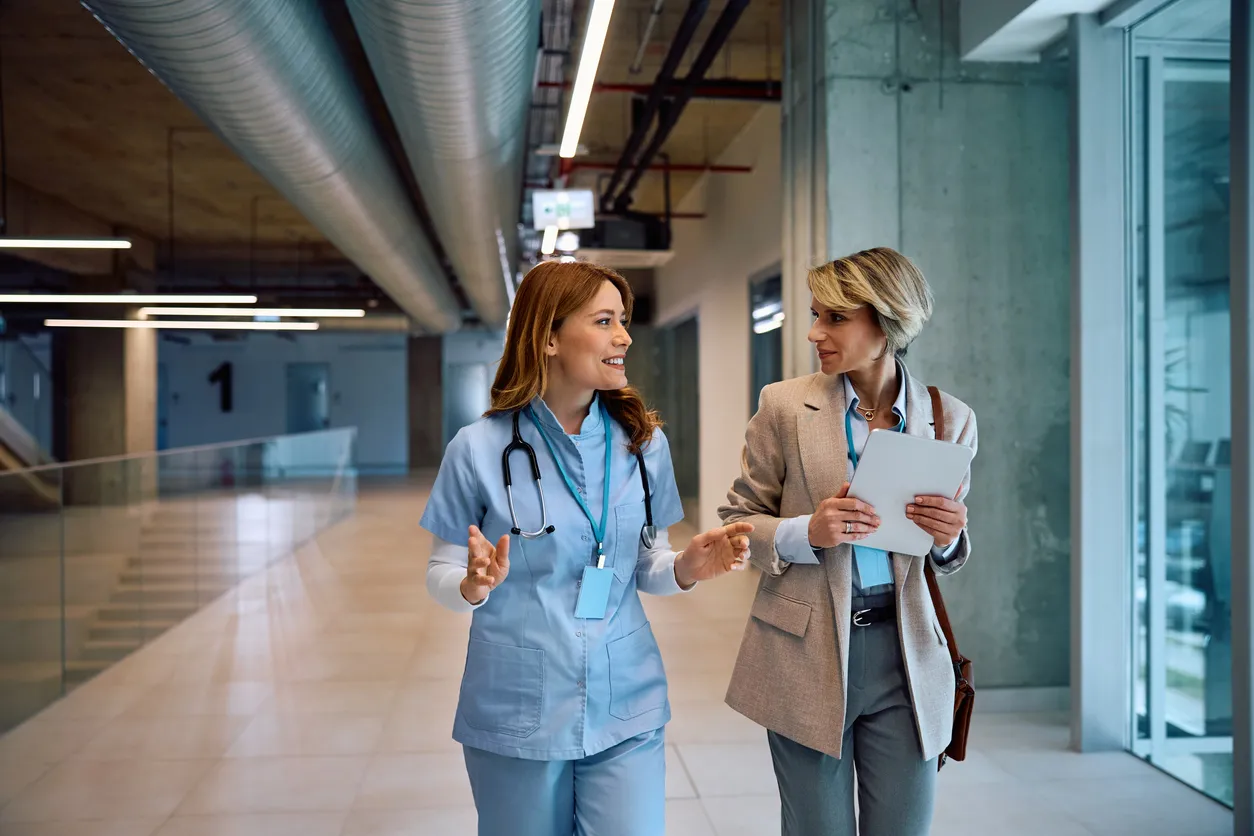 Consultora en certificaciones ISO revisando los procesos con una doctora en hospital 
