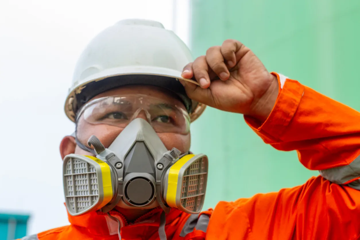 Primer plano de un hombre del sudeste asiático como trabajador de la construcción con una máscara de respiración y gafas 