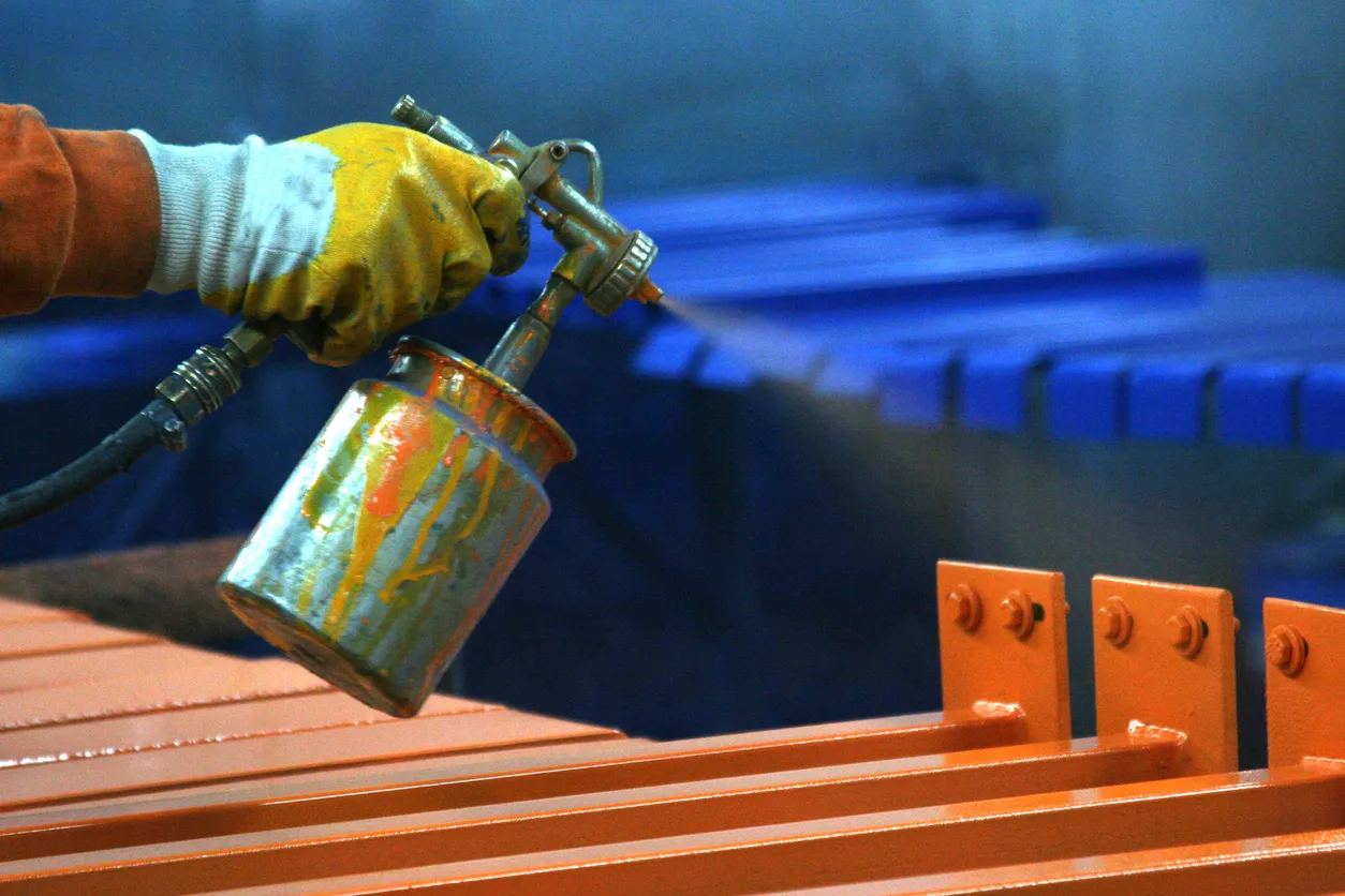 Trabajador de pintura metálica en fábrica