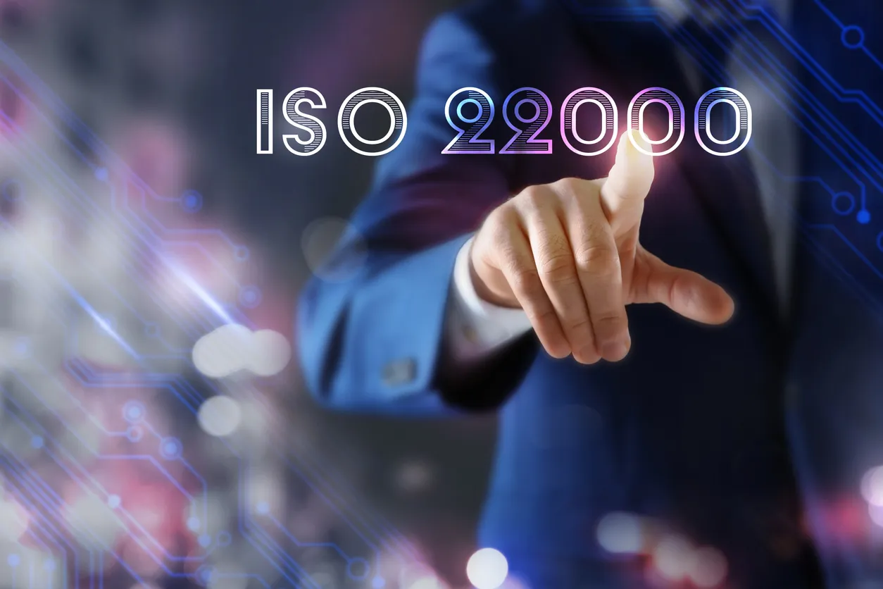 Hombre apuntando a la pantalla virtual con texto ISO 22000, primer plano