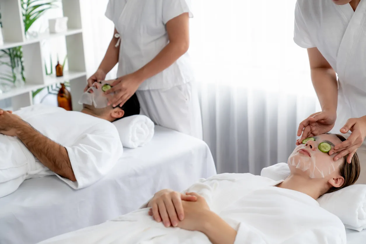 Una pareja de clientes disfruta de un tratamiento en un SPA con dos jovenes con scrubs 