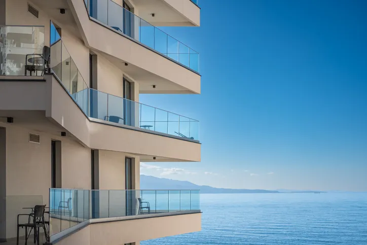 Moderno edificio de apartamentos sobre cielo azul y fondo marino. Hermoso edificio de detalle de arquitectura con balcones 