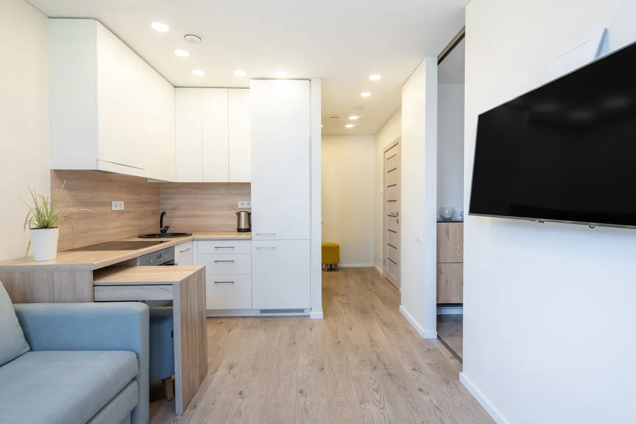 Interior de apartamento moderno y compacto con cocina contemporánea y suelos de madera