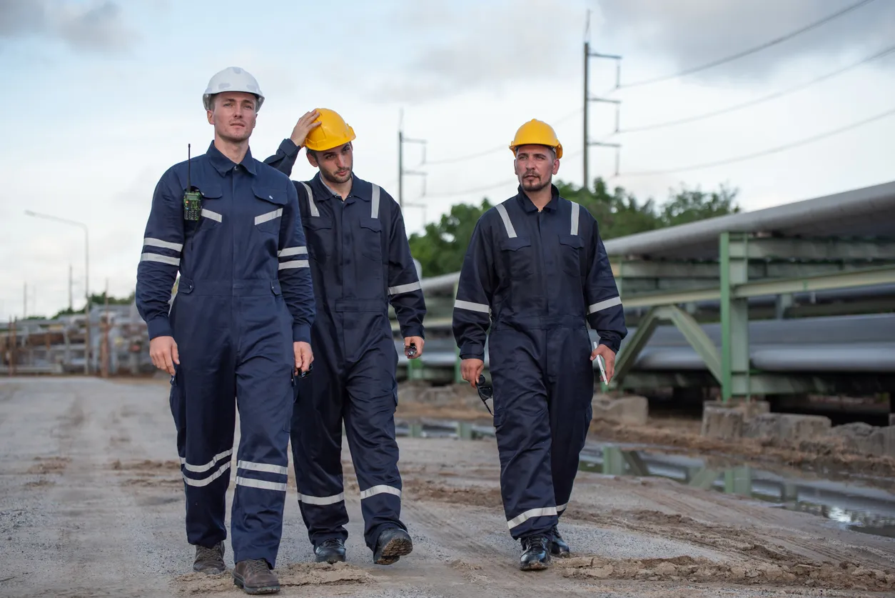 Trabajadores con overoles con cinta HI V