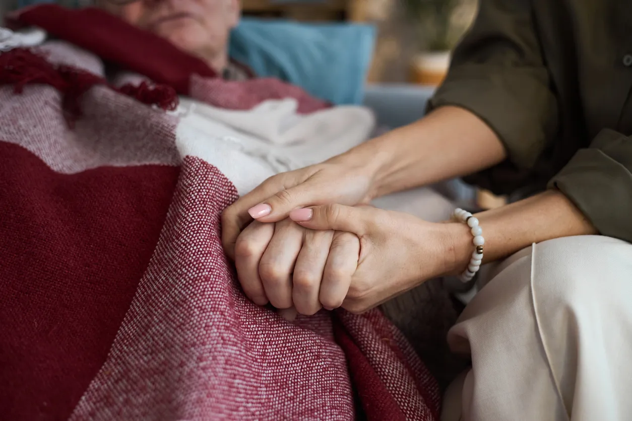Mujer de mediana edad consolando a un hombre mayor en la cama