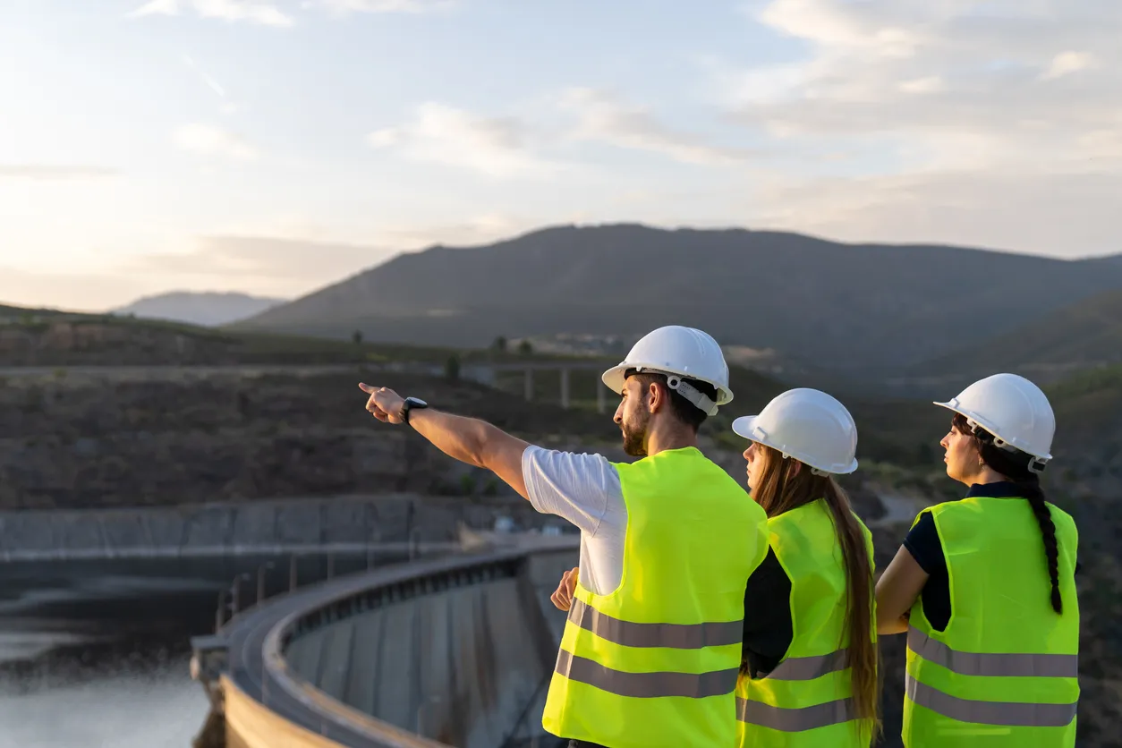 Ingenieros inspeccionando una presa al atardecer