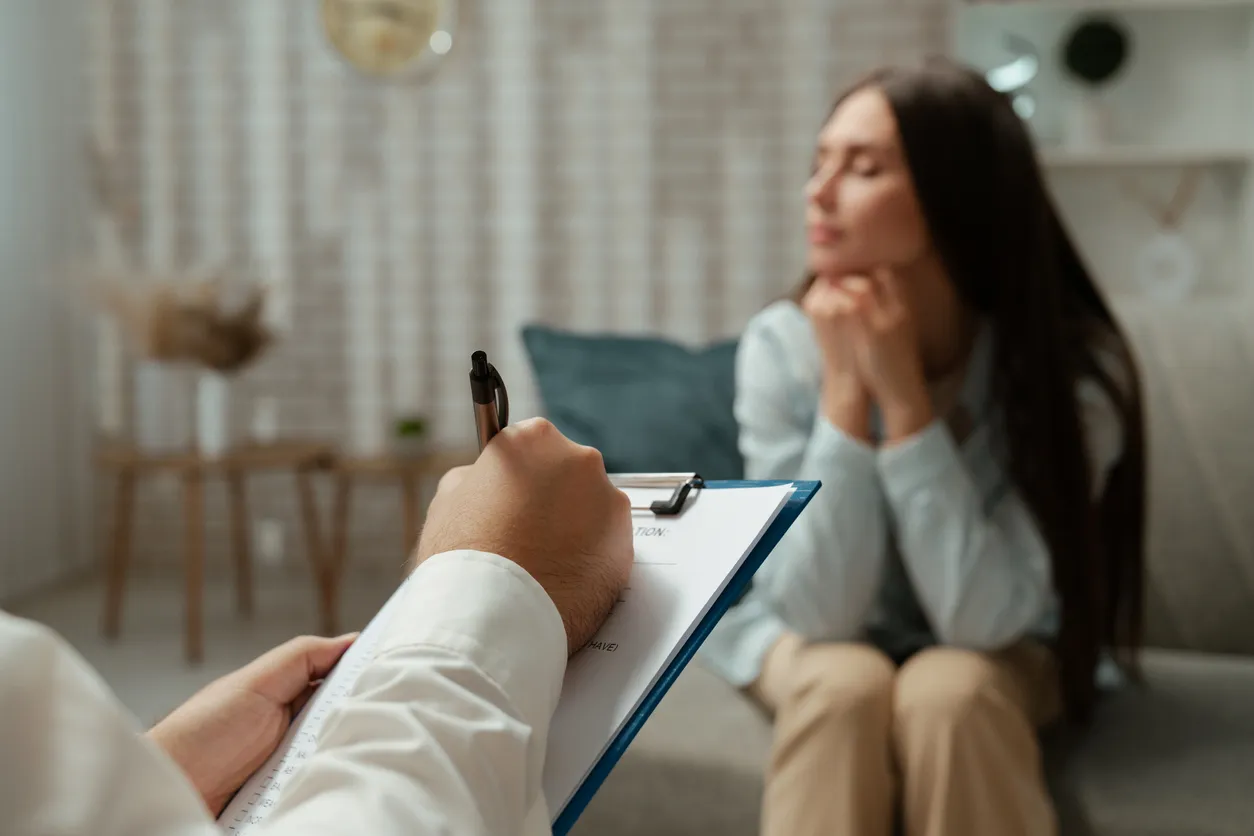 Terapeuta que consulta a un paciente durante la sesión de evaluación psicológica