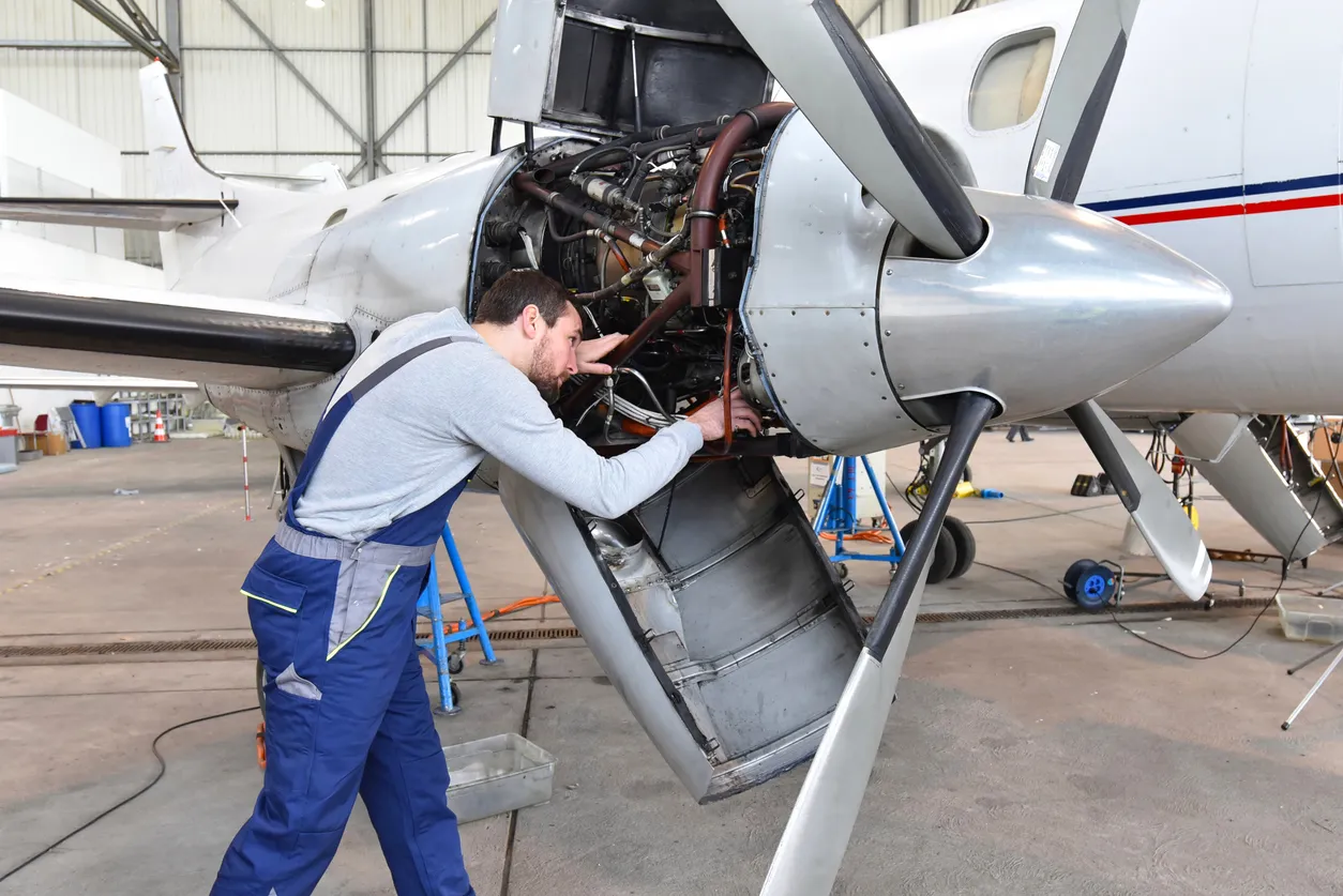 Mecánico de aeronaves repara un motor de avión en un hangar de aeropuerto