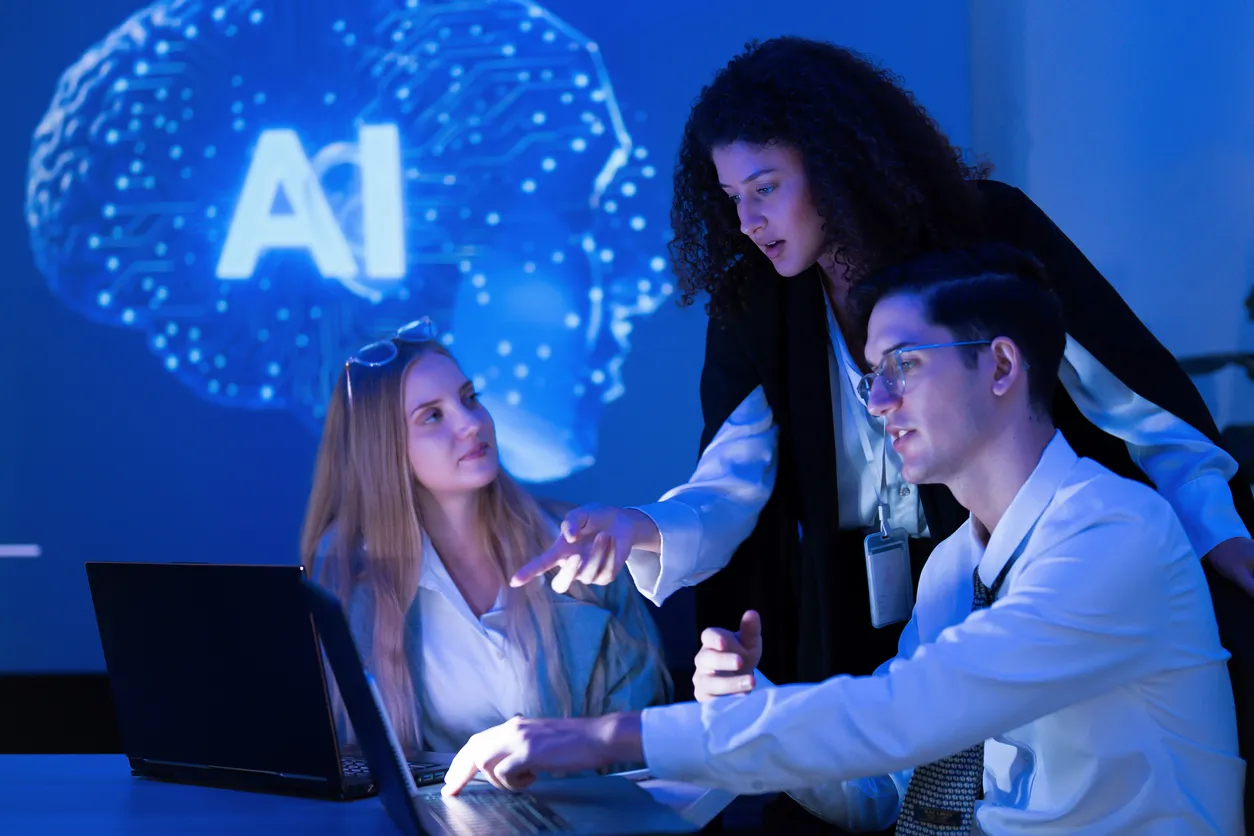 El equipo colabora en un proyecto de inteligencia artificial en un espacio de trabajo moderno con iluminación azul 
