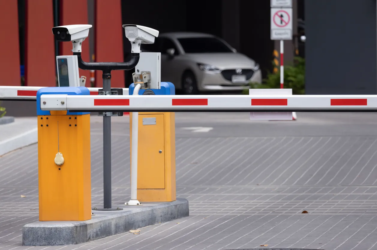 Una barrera de tráfico amarilla y azul con dos cámaras en la parte superior. Sistema de entrada automática