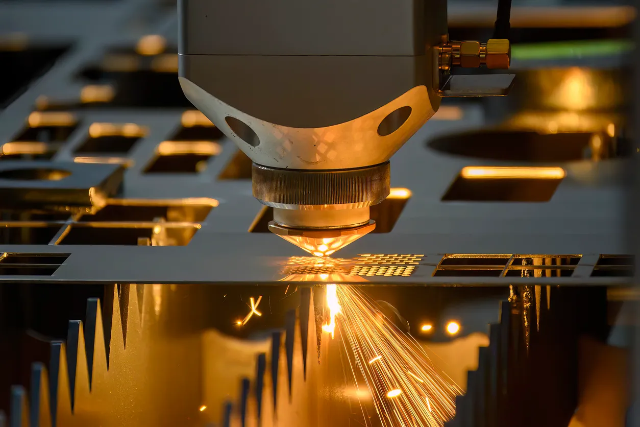 La máquina de corte por láser de fibra cortó la placa de metal con la luz brillante.