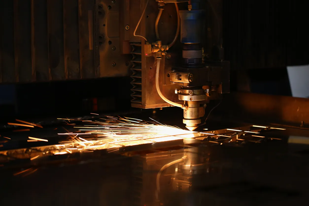 Las chispas salen volando de la máquina automatizada, el láser de procesamiento de metales en el fondo metalúrgico 