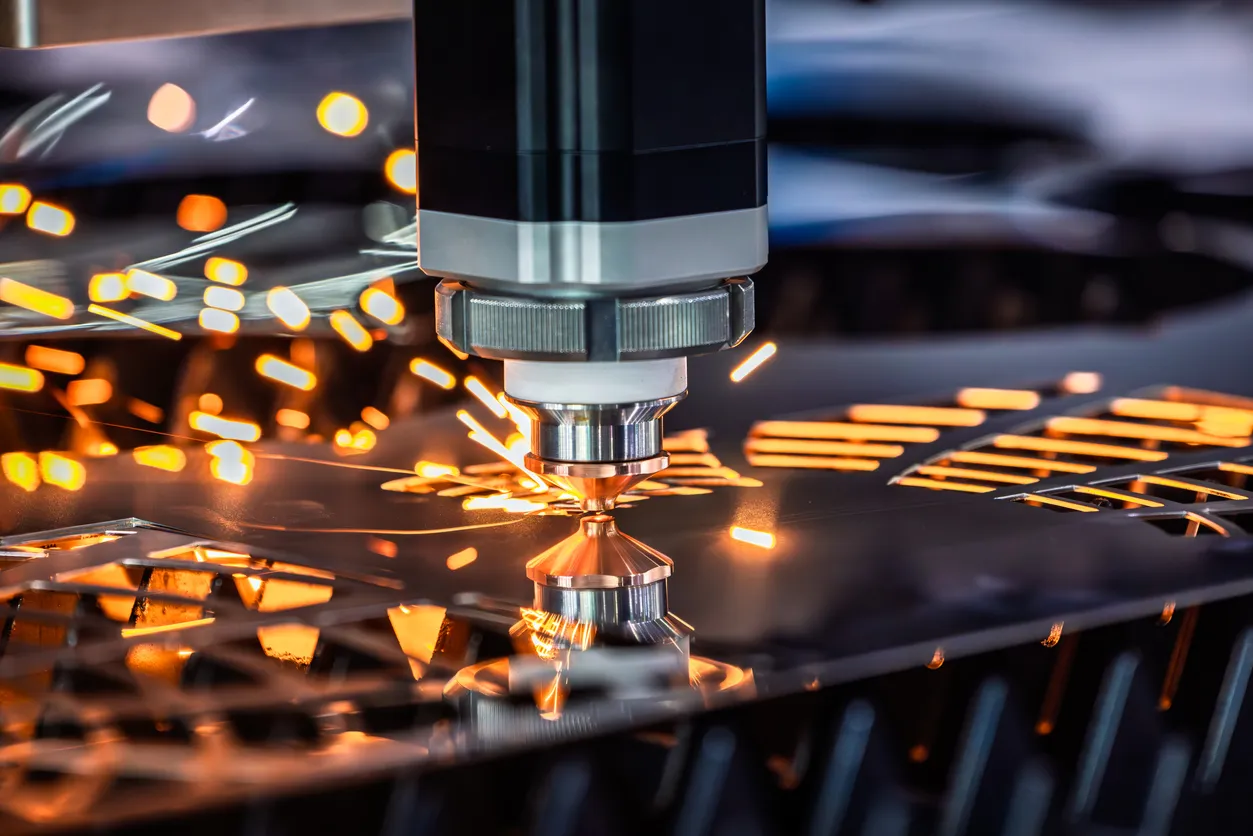 Máquina industrial CNC de corte láser con chispas voladoras en la fabricación metálica.