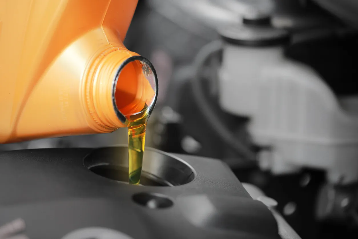 De cerca, verter aceite de motor para motor de coche. 