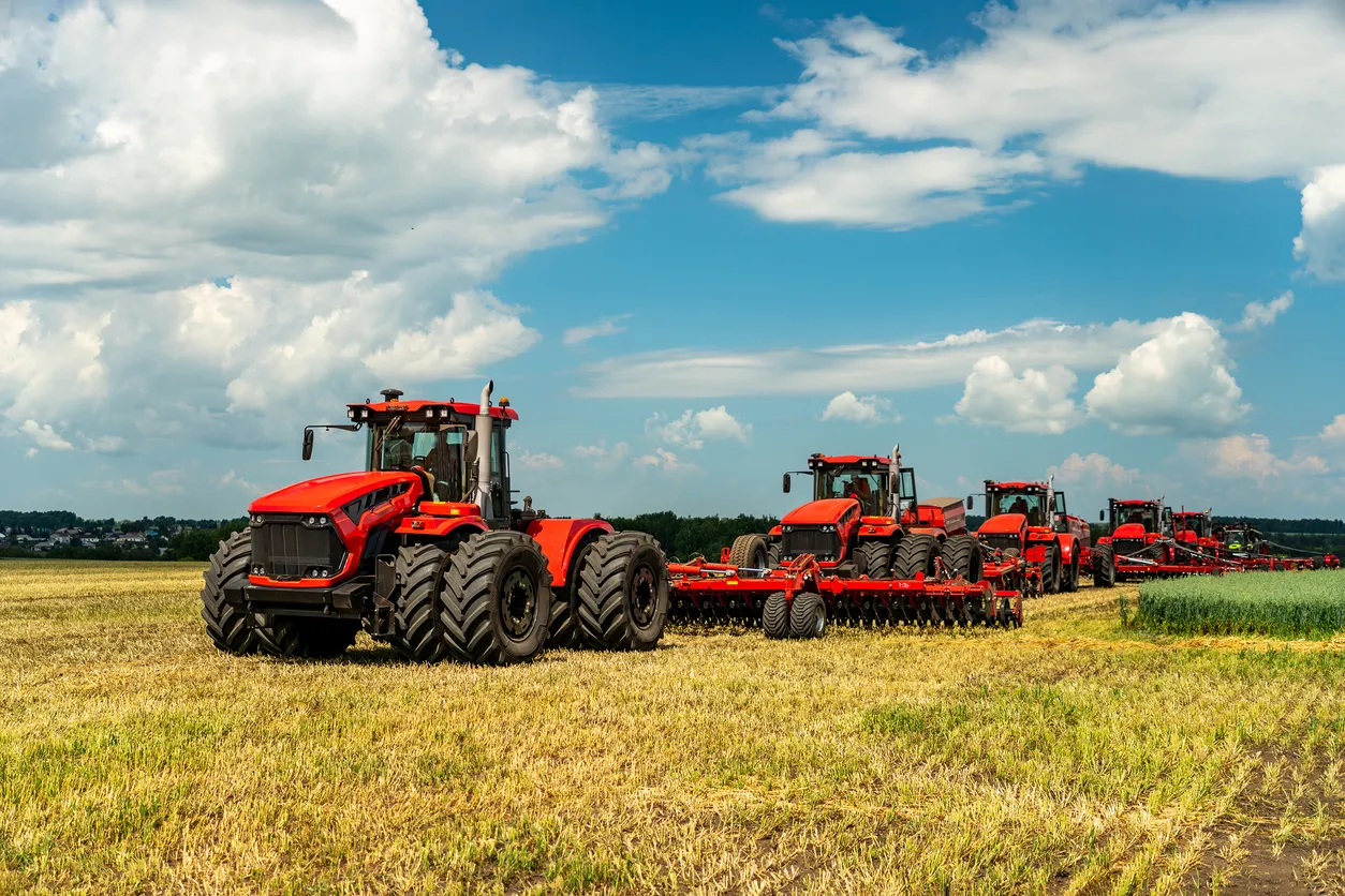 Agricultura. tractores en el campo sobre el fondo de nubes azules