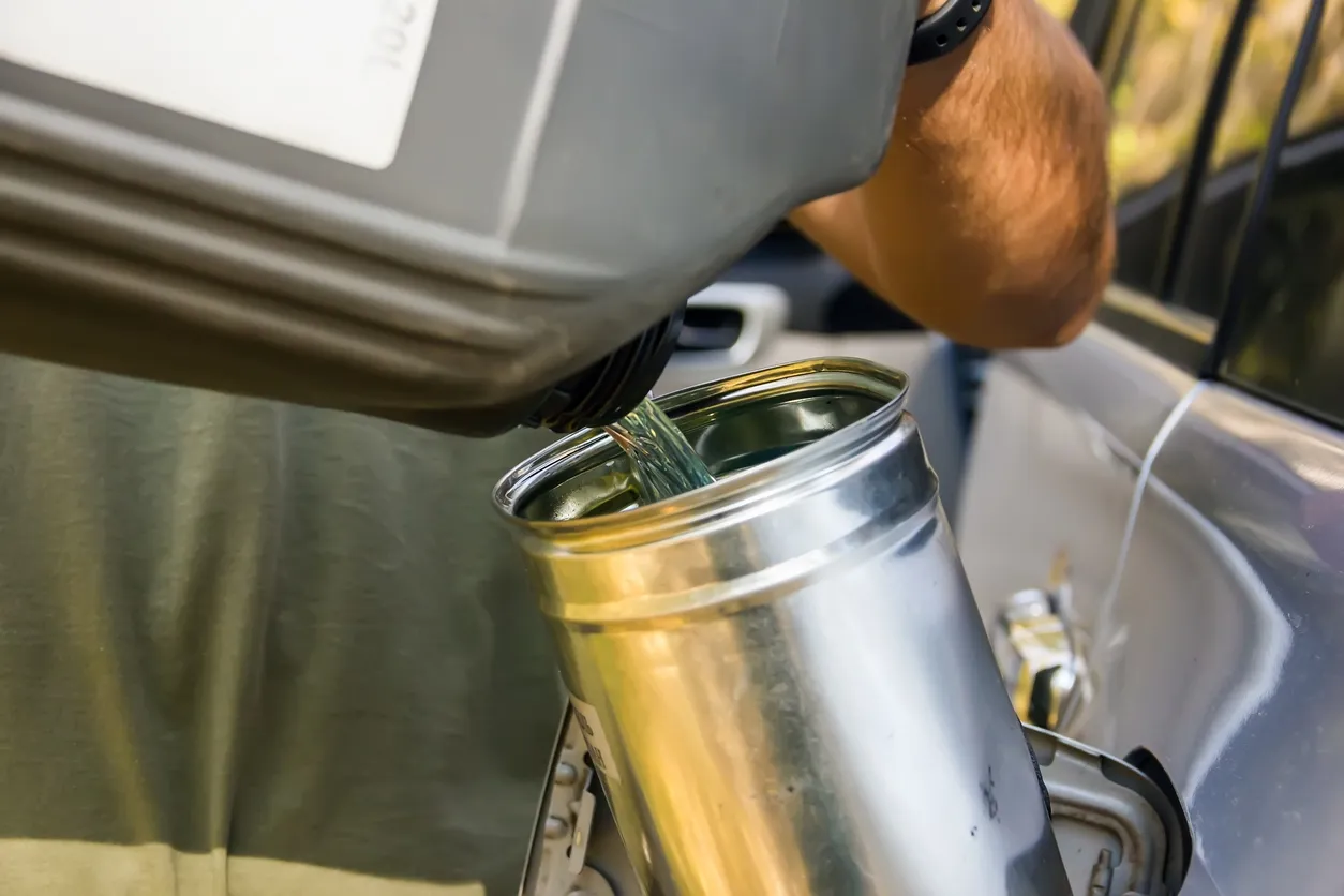 Trabajador masculino añade un aditivo al combustible diesel. 
