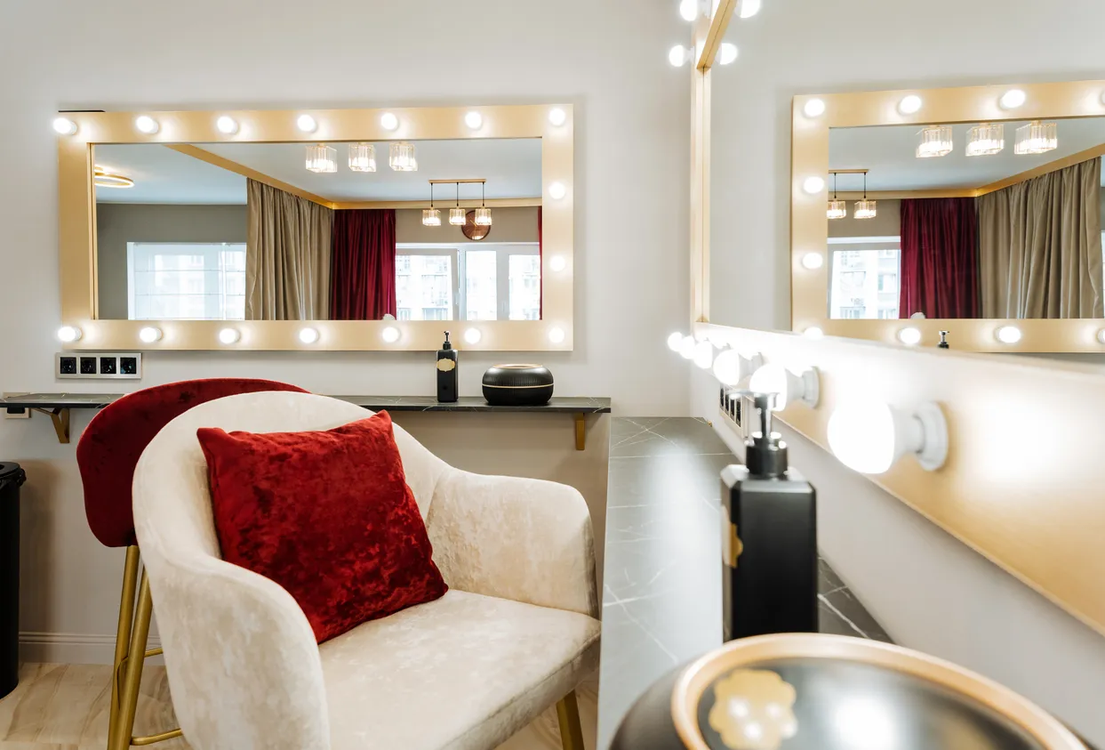 Salon de belleza con dos enormes espejos rectangulares con focos