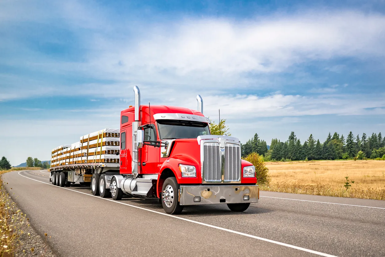 Semirremolque de plataforma grande con capó rojo brillante con accesorios cromados