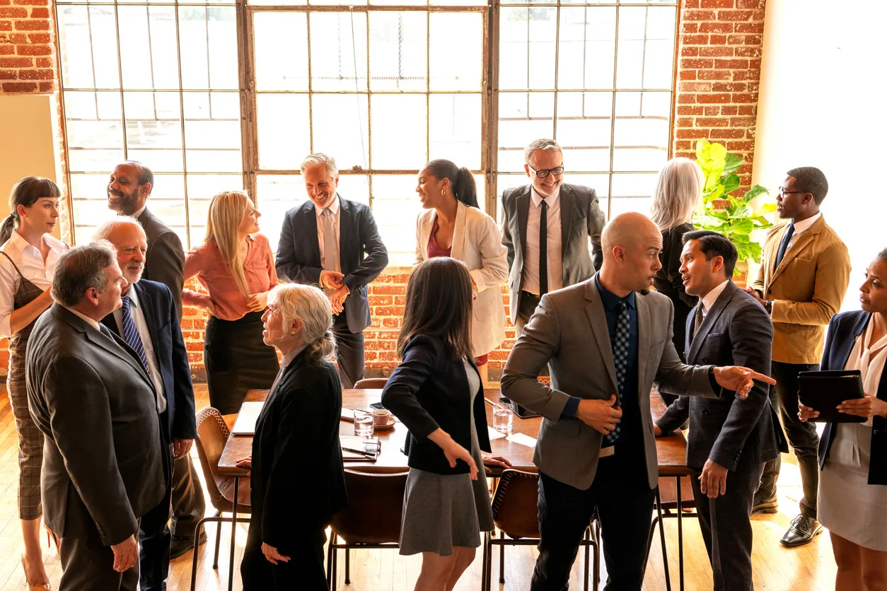 Gran grupo de empresarios en diversos grupos hablando de negocios