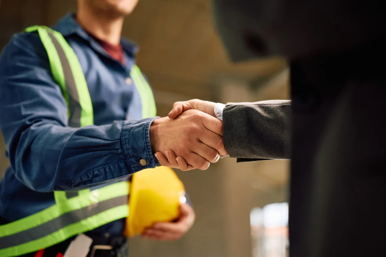 Dos ejecutivos industriales estrechandose la mano para cerrar un negocio
