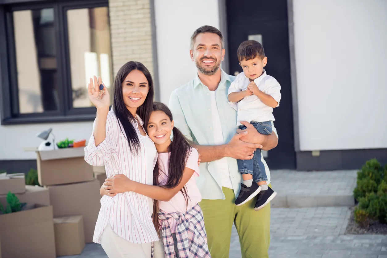Familia feliz al frente de su nueva casa