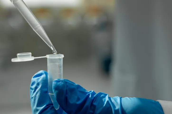 Goteo de líquido desde una pipeta hacia un tubo de ensayo en un laboratorio