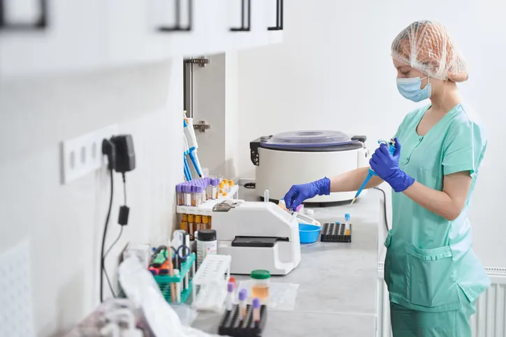 Una especialista en un laboratorio clinico con una variedad de equipo