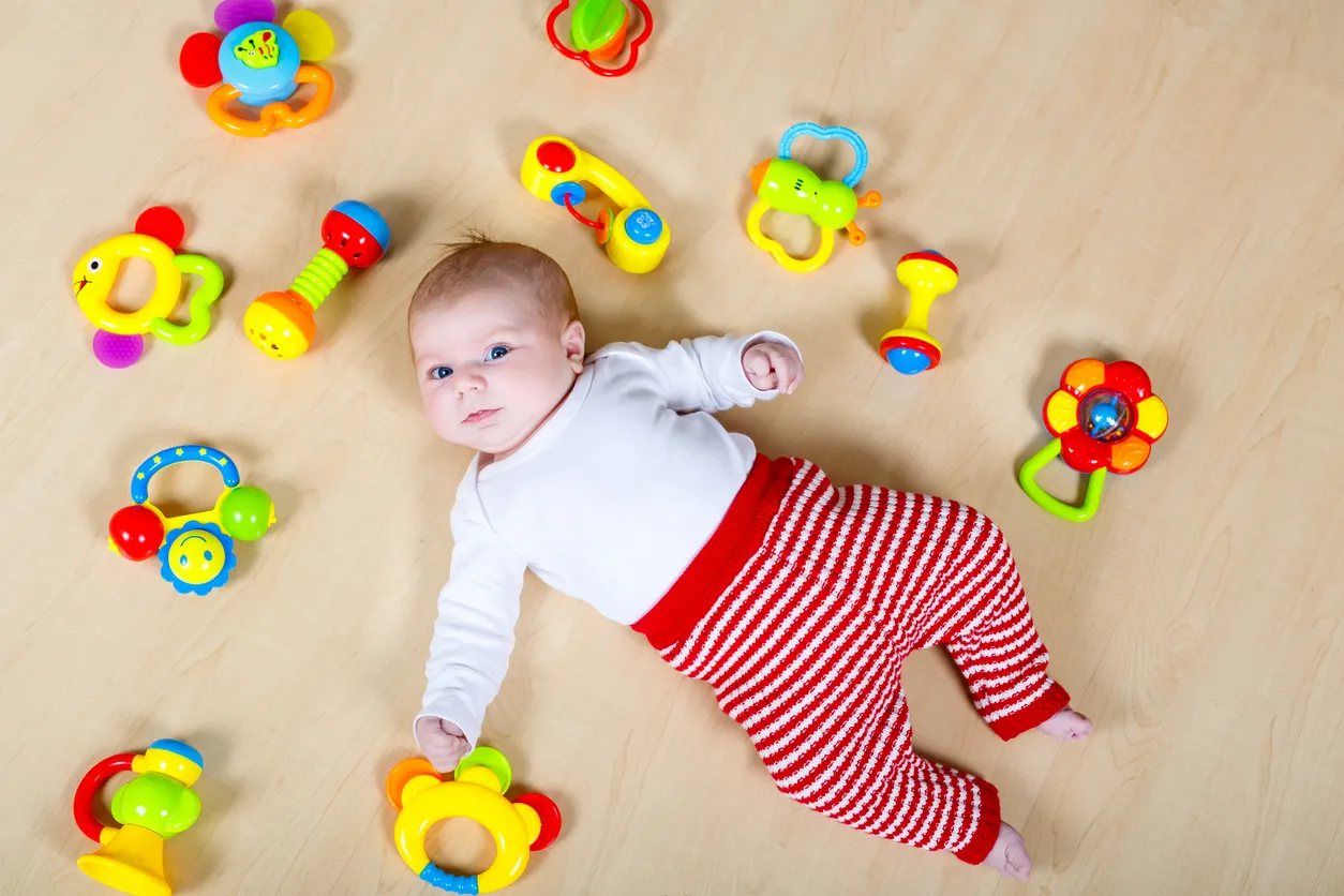 Niña linda jugando con juguetes colorido sonajero