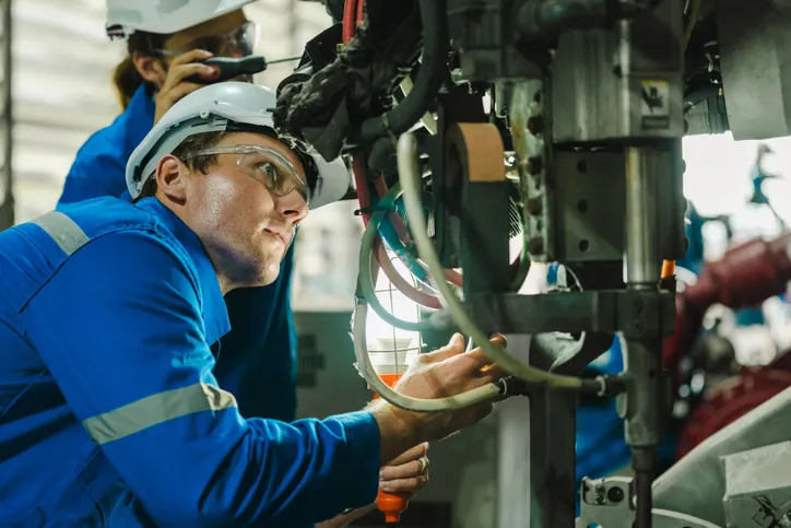 Ingenieros en fábrica revisando una maquina