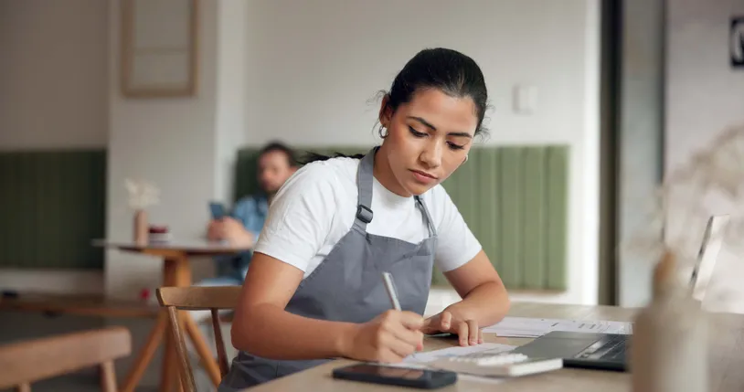 mujer adulta joven con overol de trabajo estudiando 