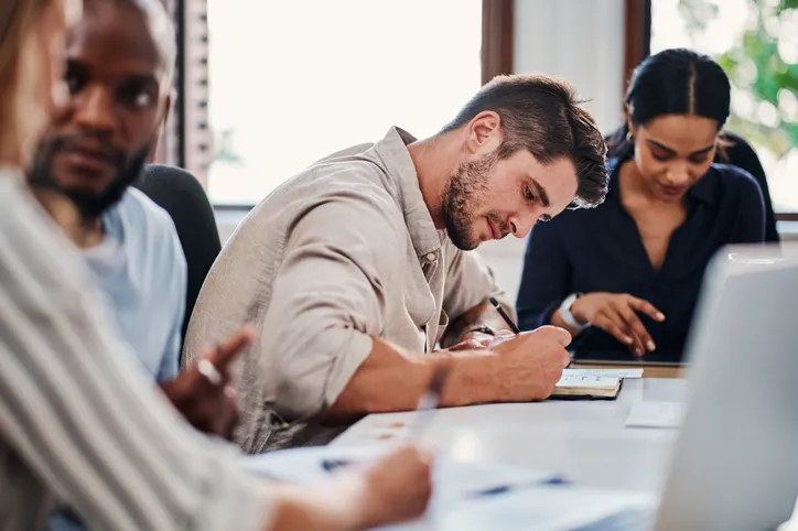 varios trabajadores estudiando en sala de capactiación 