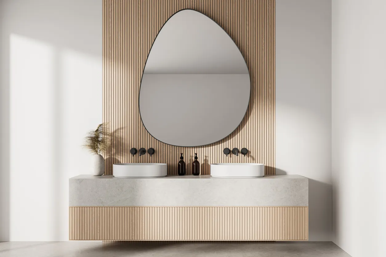 Interior de baño moderno y minimalista con pared de listones de madera y un gran espejo de forma irregular
