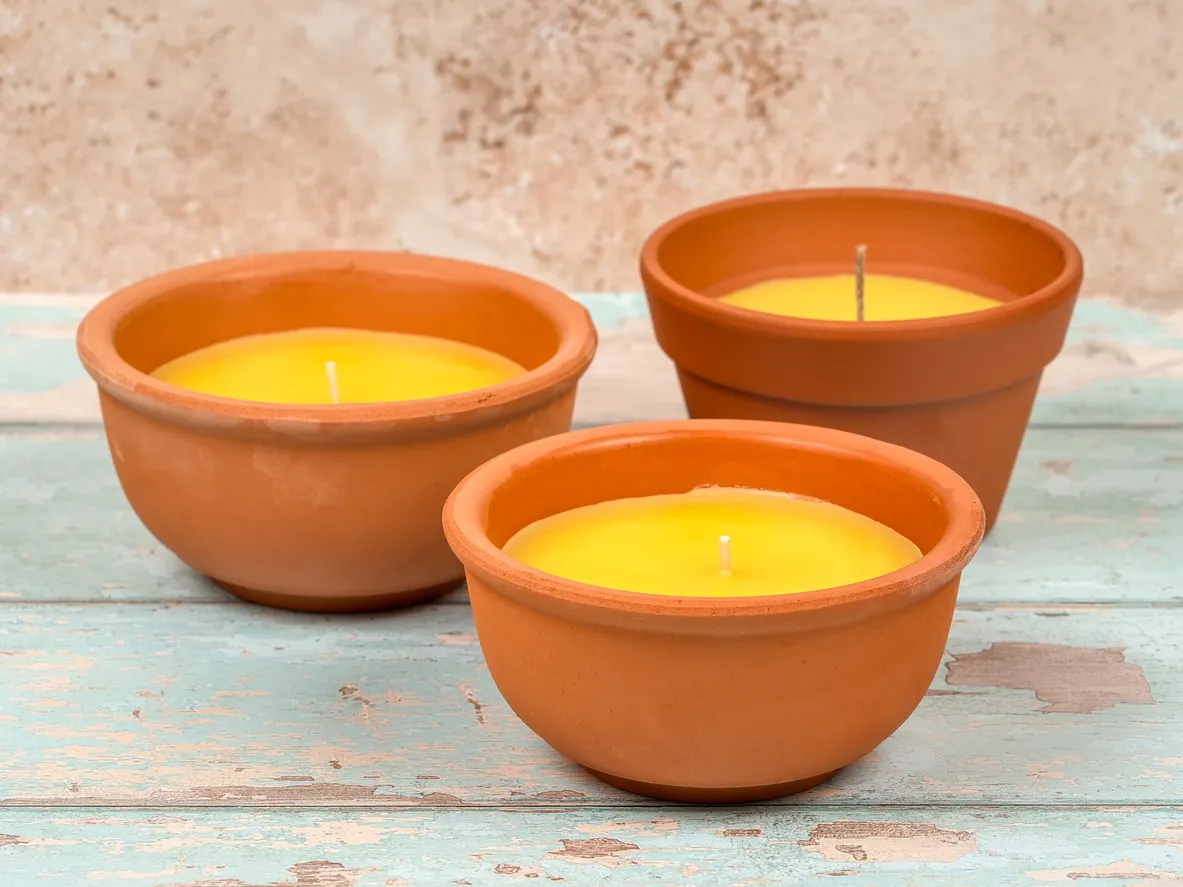 Velas de citronela en macetas de barro. Repelente de mosquitos para exteriores.
