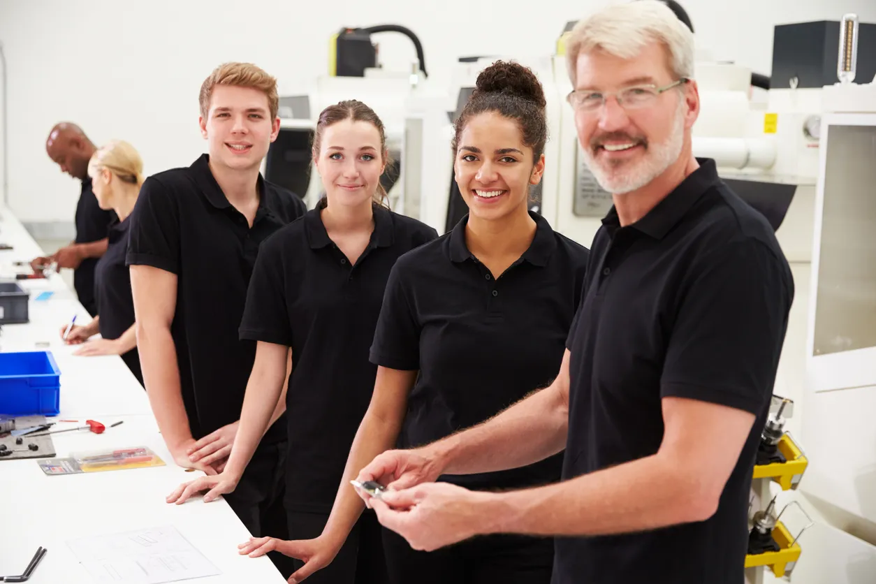 Ingenieros en laboratorio de electrónica con uniforme con playera polo color negro