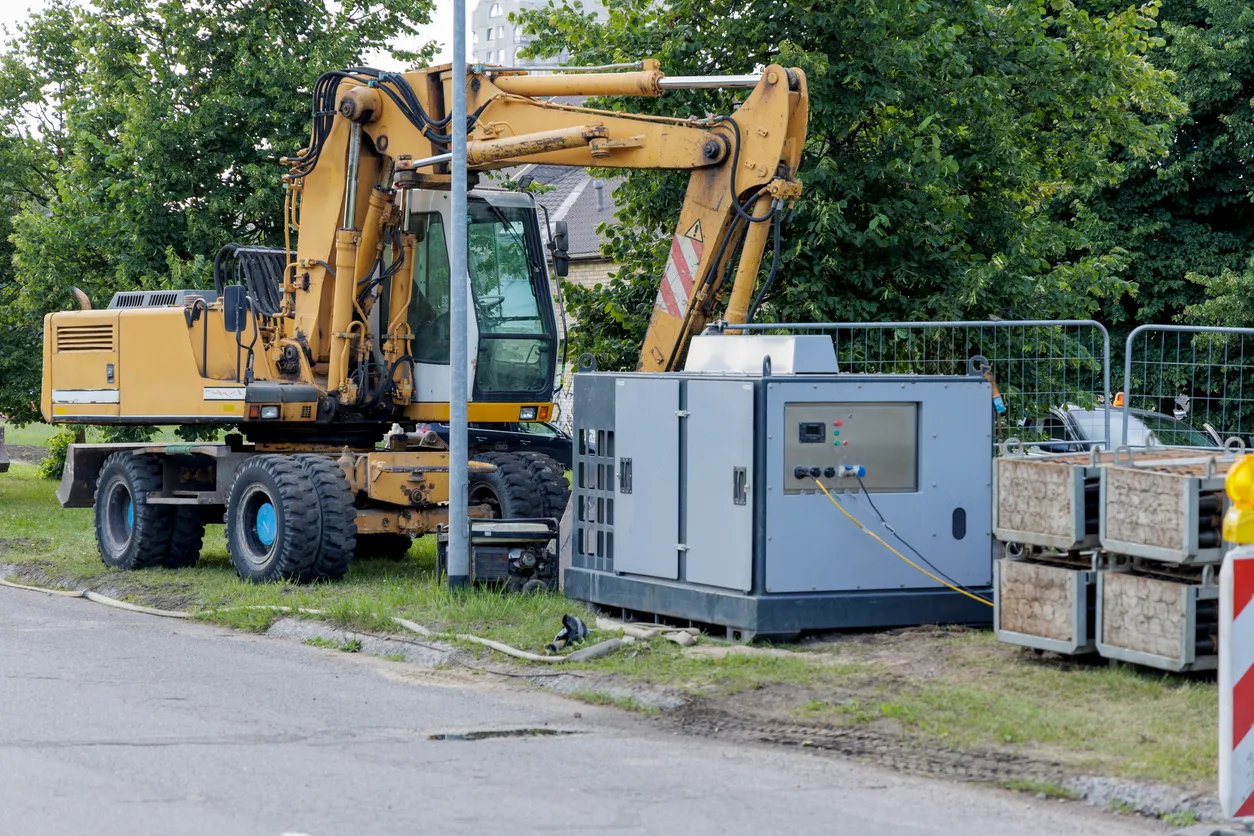 Sitio de construcción con excavadora y generador