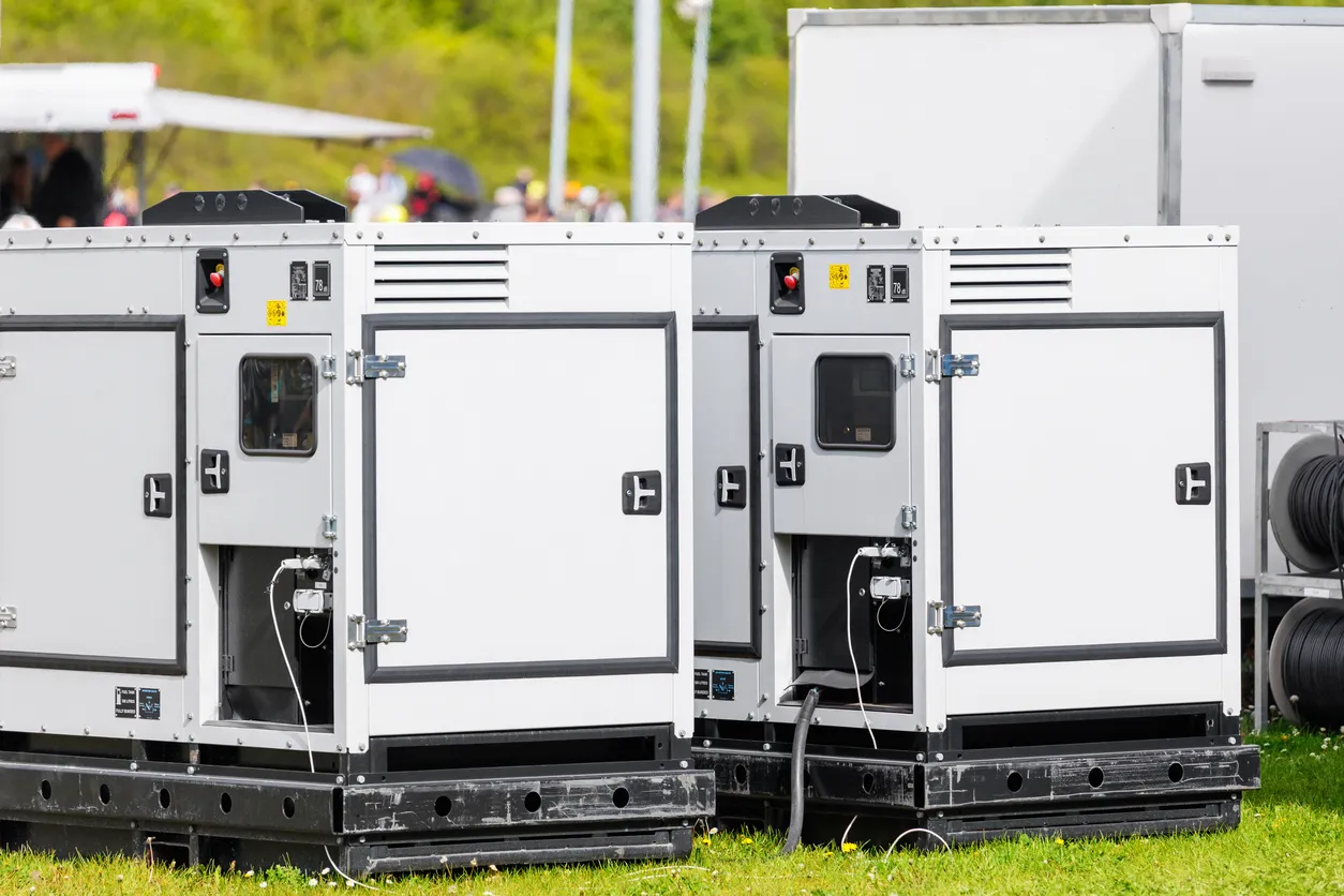 Dos grandes generadores de combustible de energía industrial portátiles con césped verde en un evento comercial