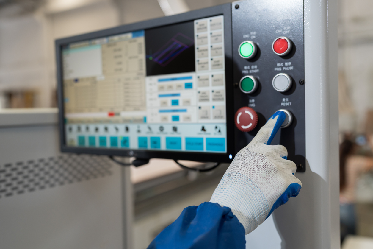 Tecnología, concepto de fabricación industrial Las manos del operador controlan la máquina CNC con panel de control 