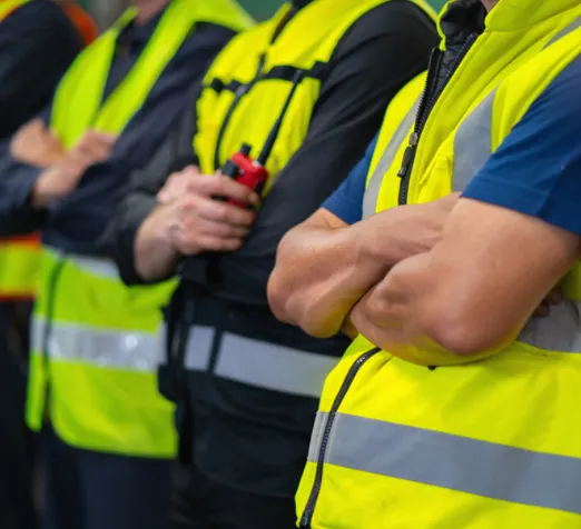 Varios hombres de seguridad privada con chalecos de seguridad