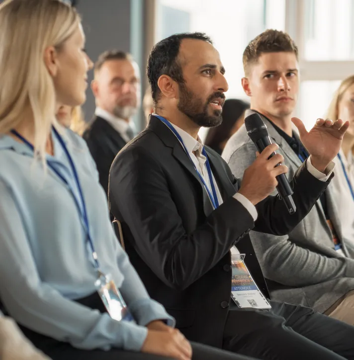 Persona hablando mediante un microfono en una capacitación de agentes de seguros